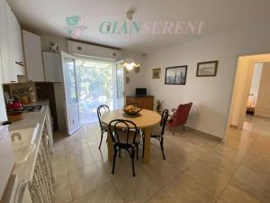 uma cozinha e sala de jantar com mesa e cadeiras em Costa - trilocale con giardino em San Vincenzo