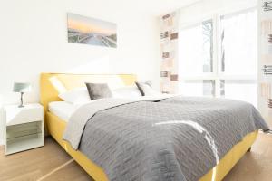 ein weißes Schlafzimmer mit einem Bett und einem Fenster in der Unterkunft Strandvilla Augustusbad Morgenstern in Scharbeutz