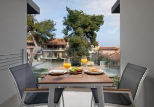 a table with glasses of orange juice and food on a balcony at CubeStudio21 in Kallithea Halkidikis