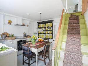 a kitchen with a table and chairs and a staircase at Seagull Cottage in Beaumaris