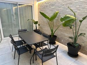 瓦倫西亞的住宿－Precioso apartamento con patio. PYP，植物阳台的桌椅