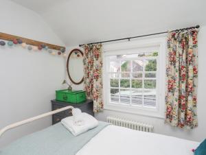 a bedroom with a bed and a window at Seagull Cottage in Beaumaris