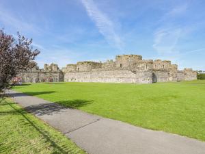 a large castle with a green field in front of it at Seagull Cottage in Beaumaris