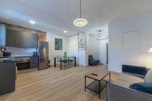 sala de estar y cocina con sofá y mesa en Centric Gracia Apartments en Barcelona