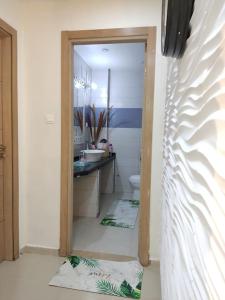 a bathroom with a sink and a toilet and a mirror at Appartement F3_urba 2000 in El Achour