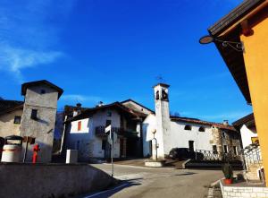 un edificio con una torre dell'orologio su una strada di Jvan Rooms Tower a Sospirolo