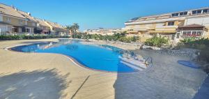 una grande piscina al centro di un resort di Suites Beach House a Playa de las Americas