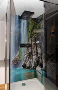 a bathroom with a shower with a waterfall mural at Chalet Young & Fun in Freyung
