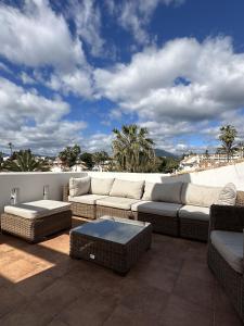 a patio with a couch and a table on a balcony at Aldea Blanca Cozy Penthouse in Puerto Banús in Marbella