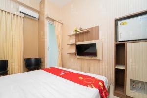 a room with a bed and a flat screen tv at RedLiving Apartemen Vivo Yogyakarta - WM Property in Yogyakarta