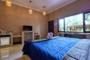 Jepun BnB Bali في سمينياك: غرفة نوم بسرير ازرق عليها حيوان محشو
