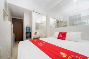 Un dormitorio con una cama con una manta roja. en RedLiving Apartemen Vivo Yogyakarta - WM Property, en Yogyakarta