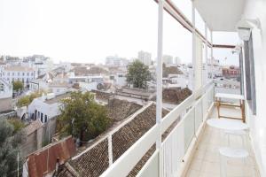 a balcony with two chairs and a view of a city at Blue Sky Apartment in Faro