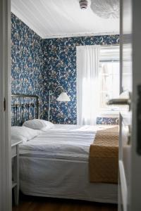 een slaapkamer met een bed met blauw bloemenbehang bij Orbaden Spa & Resort in Vallsta