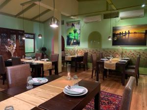a restaurant with tables and chairs and a large screen at Sala Boutique Hotel in Male City