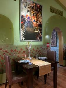 a dining room with a table and a painting on the wall at Sala Boutique Hotel in Male City