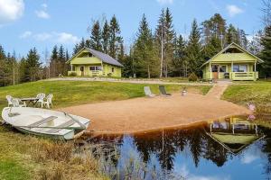 un barco sentado en el agua frente a una casa en Metsämökki, en Kelkala