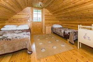 Un dormitorio con dos camas en una cabaña de madera. en Metsämökki, en Kelkala