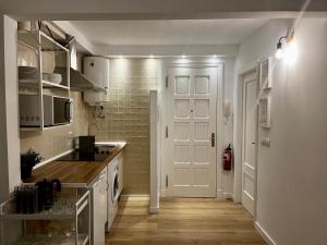 kuchnia z białymi szafkami i białymi drzwiami w obiekcie Apartamento Puerta del Camino 5 - PATIO y WIFI w mieście Bilbao +8 zdjęć