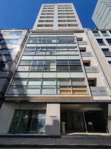 un alto edificio bianco con molte finestre di Section L Residence Ginza a Tokyo