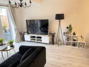 a living room with a couch and a flat screen tv at Cosy Bedrooms in Manchester