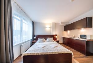 1 dormitorio con cama grande y ventana grande en Apartamenty i pokoje ,,Leśne" en Jastarnia