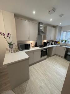 a large kitchen with white cabinets and a counter top at Cosy Bedrooms in Manchester