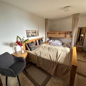 1 dormitorio con cama, silla y espejo en Haus Weitblick, en Sirnitz-Sonnseite