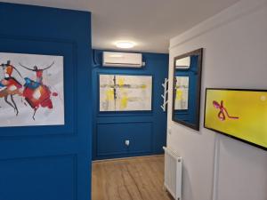 a room with blue walls and a door with paintings at Ancora apartment 5 in Novi Sad