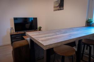 een grote houten tafel in een woonkamer met een tv bij Bonuit in Le Mans