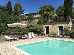 einen Pool vor einem Haus mit Sonnenschirm in der Unterkunft [Swimming pool with view] Tenuta la Macinaia in Castello di Montalto