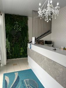 a bathroom with a green wall with a chandelier at Hotel Pousada Mar Azul in Itapoa
