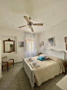 Schlafzimmer mit einem Bett und einem Deckenventilator in der Unterkunft [Swimming pool with view] Tenuta la Macinaia in Castello di Montalto