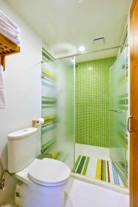 a bathroom with a toilet and a glass shower at Shire Homestay in Luodong