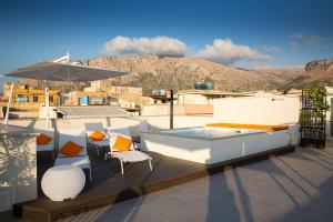 a rooftop deck with a hot tub and chairs and an umbrella at Giada Luxury Terrasini in Terrasini