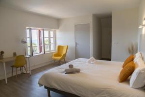 1 dormitorio con 1 cama blanca grande y 2 sillas en Résidence Musicale Haut 2 Gammes - Gîte en Saint-Hippolyte