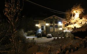 a house at night with snow covered trees and lights at Casa Carielda in Pembes