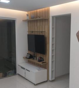 uma sala de estar com uma televisão na parede em Apartamento completo Ilheus em Ilhéus