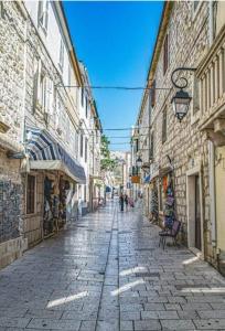 an empty street in an old town with buildings at Apartments Alma in Pag
