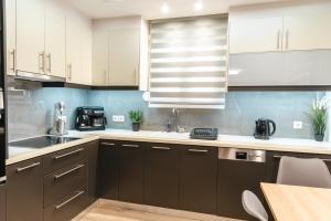a kitchen with white and brown cabinets and a table at Elegant decorated house - Free Private Parking! in Heraklio Town
