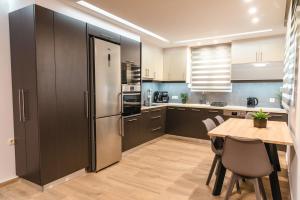 a kitchen with a table and a stainless steel refrigerator at Elegant decorated house - Free Private Parking! in Heraklio Town