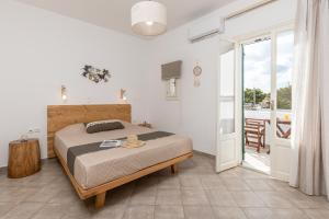 a bedroom with a bed and a balcony at Sunshine in Naxos Chora