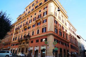 duży budynek na ulicy miejskiej z samochodami zaparkowanymi przed w obiekcie Caterina One o One - Embassy Apartment w Rzymie