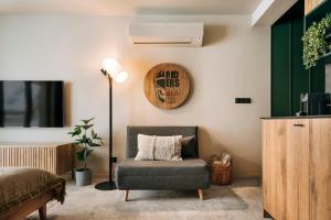 a bedroom with a chair and a clock on the wall at Apartamenty Riders Lodge Kościelisko Chotarz Bór in Kościelisko