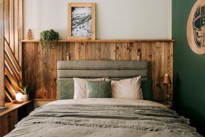 a bedroom with a large bed with a wooden wall at Apartamenty Riders Lodge Kościelisko Chotarz Bór in Kościelisko