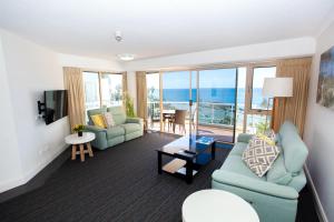 a living room with couches and a view of the ocean at Osprey Apartments in Mooloolaba