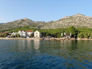 a view of the shore of a lake with mountains in the background at Apartman MASLINA in Starigrad-Paklenica