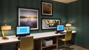 a office with two computers on a desk with two chairs at Hyatt House Naples 5th Avenue in Naples