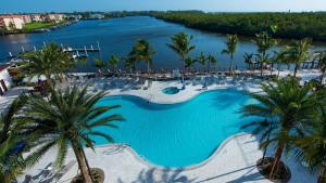 an aerial view of a pool with palm trees and water at Hyatt House Naples 5th Avenue in Naples