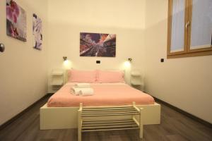 Dormitorio pequeño con cama con manta rosa en Harmony Sirmione - Affitti Brevi Italia, en Sirmione